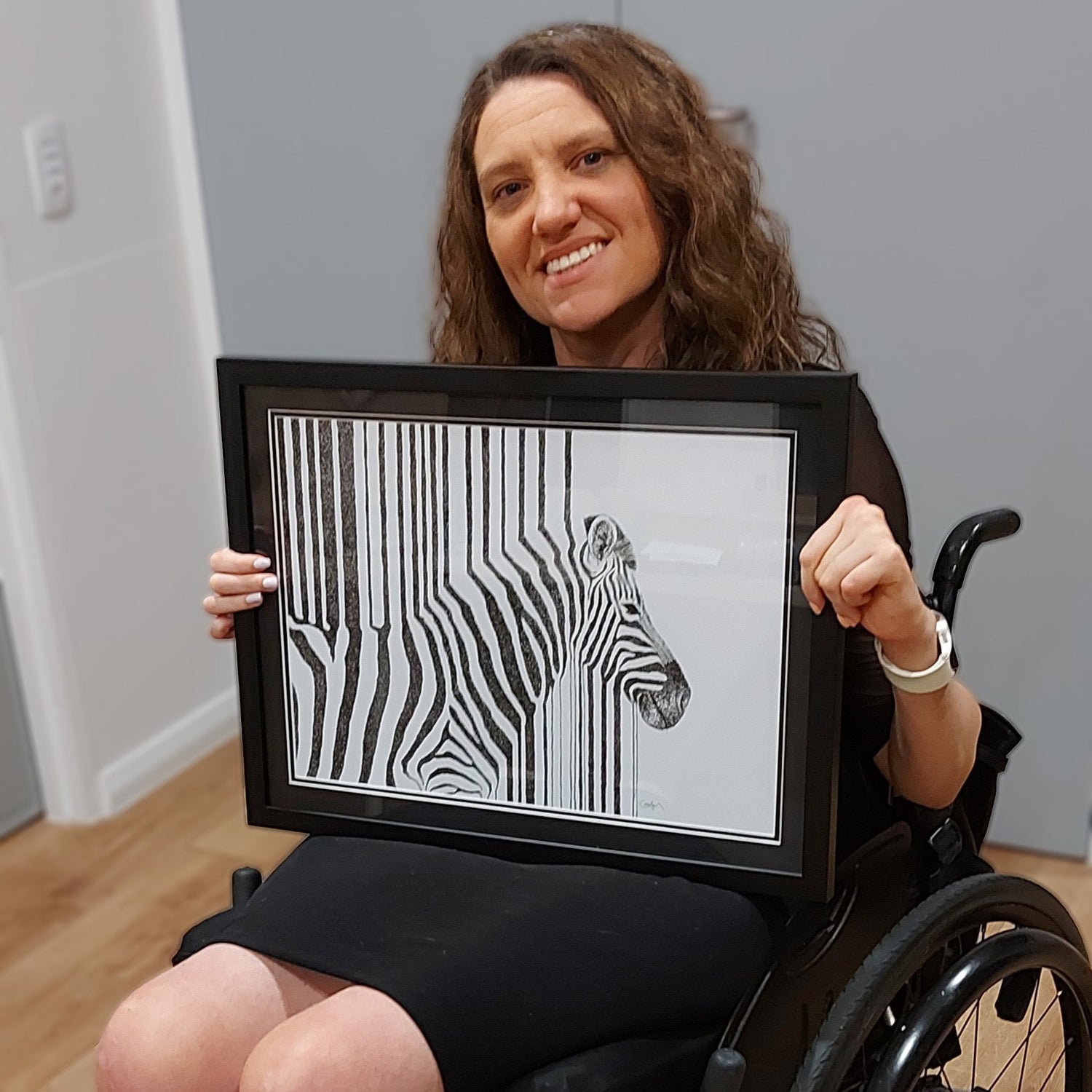 Cobie holding a framed print of Neuroplasticity