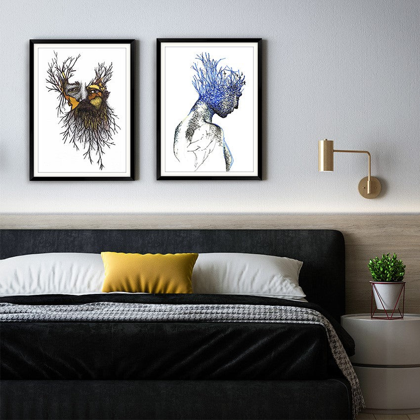 Two ARTWORKS BY Cobie Ann Moore FRAMED IN BLACK FRAMES ABOVE A BED 